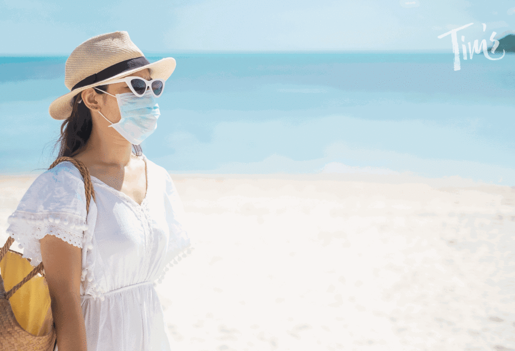 traveler on beach in Cancun with mask on for safety