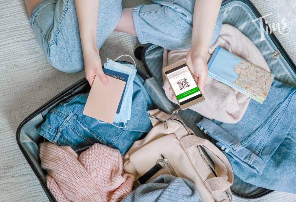 Woman holding her passport while packing essential items into a suitcase for her Cancun vacation, highlighting the importance of travel insurance for vacation rentals.