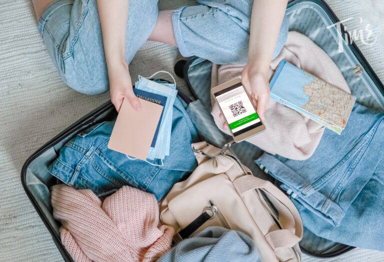 Woman holding her passport while packing essential items into a suitcase for her Cancun vacation, highlighting the importance of travel insurance for vacation rentals.