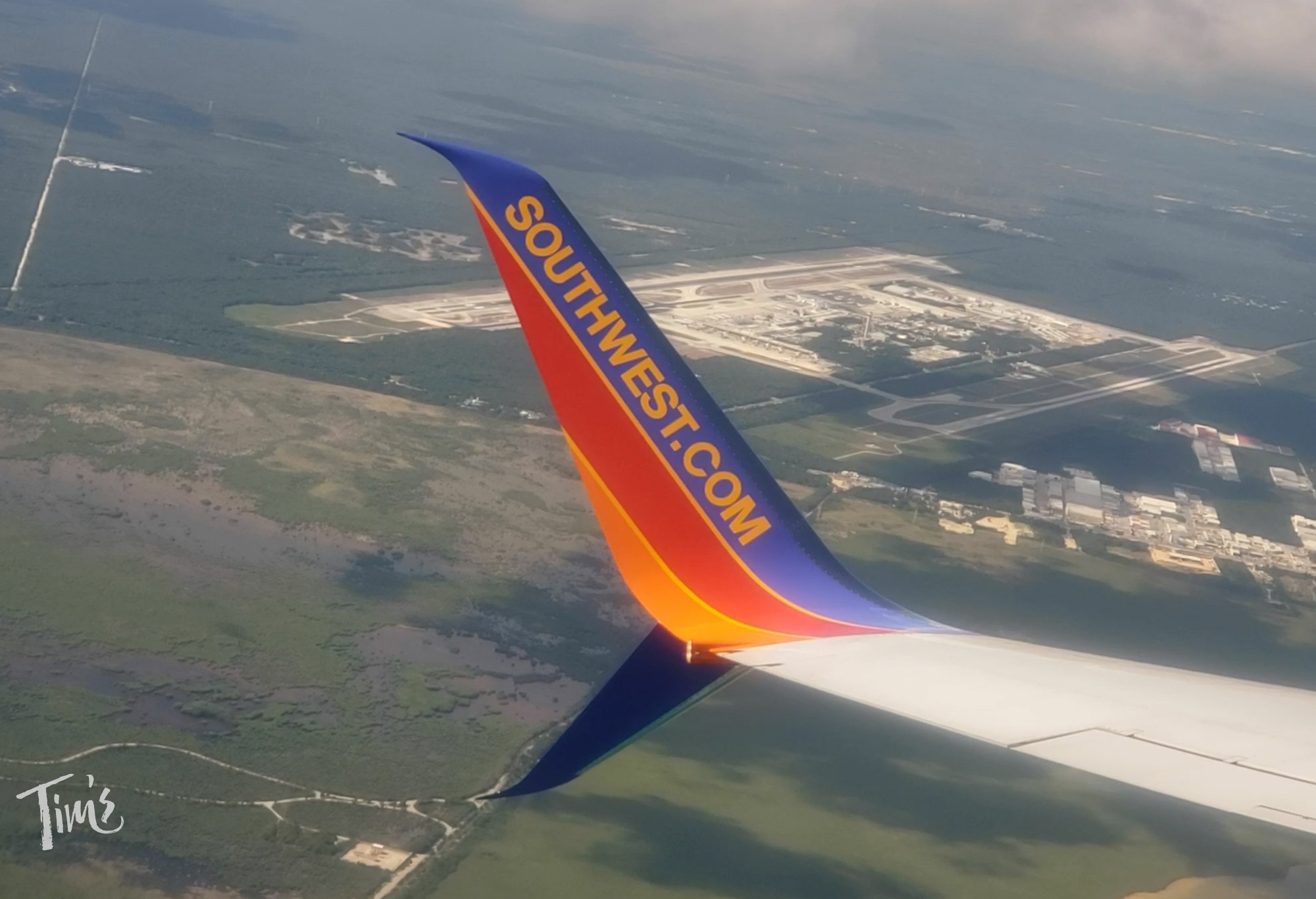 View from Southwest Airlines window with wingtip logo and Cancun Airport in the background