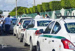 Taxi cars backed up in front of Cancun International Airport during a 2024 protest by taxi drivers against Uber.