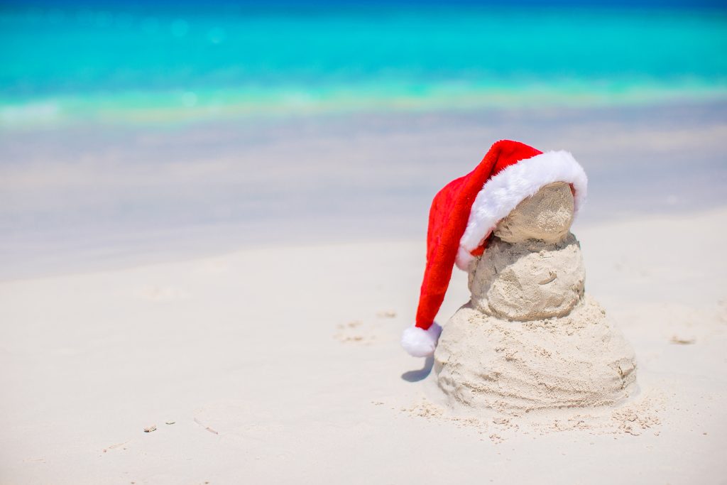 A sand snowman with a Santa hat on its head, built on the beach at Tim's Ocean Condos in Cancun.