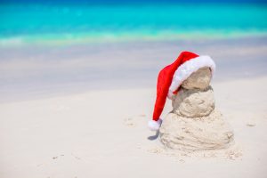 A sand snowman with a Santa hat on its head, built on the beach at Tim's Ocean Condos in Cancun.