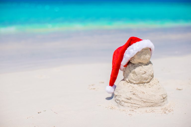A sand snowman with a Santa hat on its head, built on the beach at Tim's Ocean Condos in Cancun.
