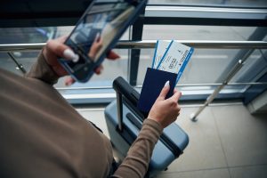 Woman at Cancun Airport holding airline tickets, verifying VISITAX payment was made and ensuring Mexico Departure Tax is included on her airline ticket.