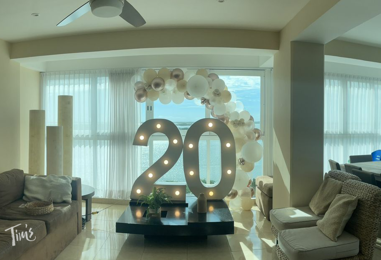 Anniversary decorations in Cancun featuring 4-foot-tall marquee sign with the number 20 and Calm Beach balloon collection in white, sand, metallic champagne, cream, and transparent colors.