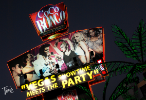 Nighttime view of Coco Bongo's exterior sign in Cancun, featuring impersonators of Elvis, Madonna, and Britney Spears.