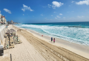 Freshly cleaned beach in front of Tim's Ocean Condos showing clear sand and seaweed-free shoreline in Cancun, July 2025.