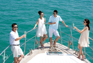 Four guests enjoying champagne on the front deck of a private yacht arranged by Tim’s Ocean Condos in Cancun