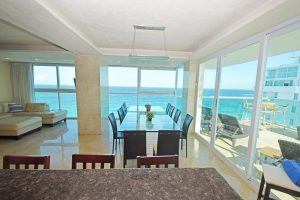 Wide-angle view of Penthouse 2701 at Tim’s Ocean Condos with floor-to-ceiling windows, family room, dining area, and Caribbean sunrise terrace.