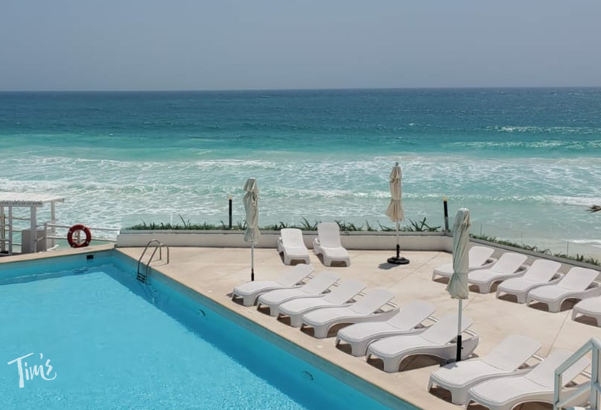 Empty lounge chairs by the pool at ÓLEO Cancún Playa® in Cancun