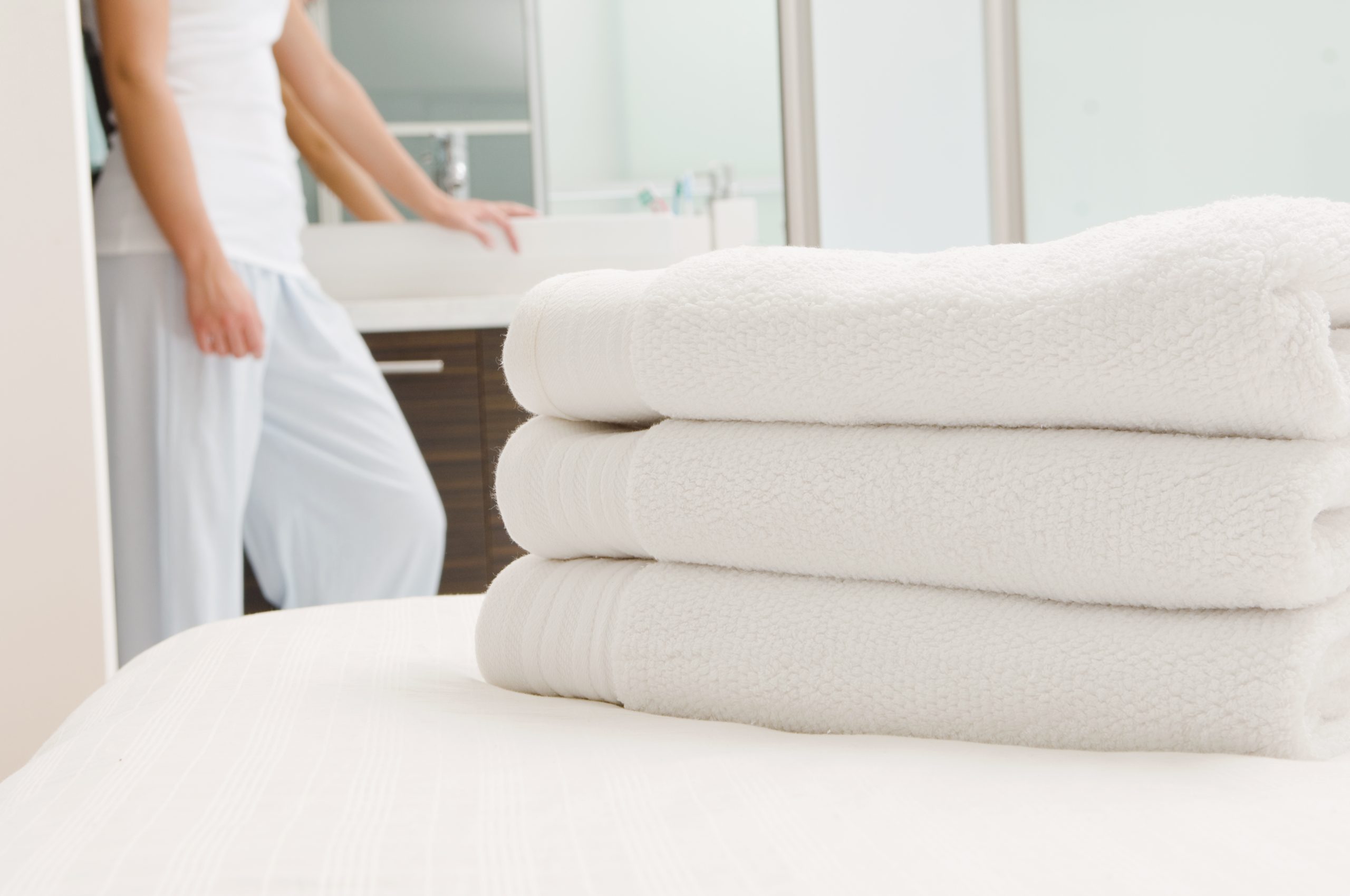 Clean white folded towels on a freshly made bed representing additional maid service available at Tim's Ocean Condos vacation rental Cancun