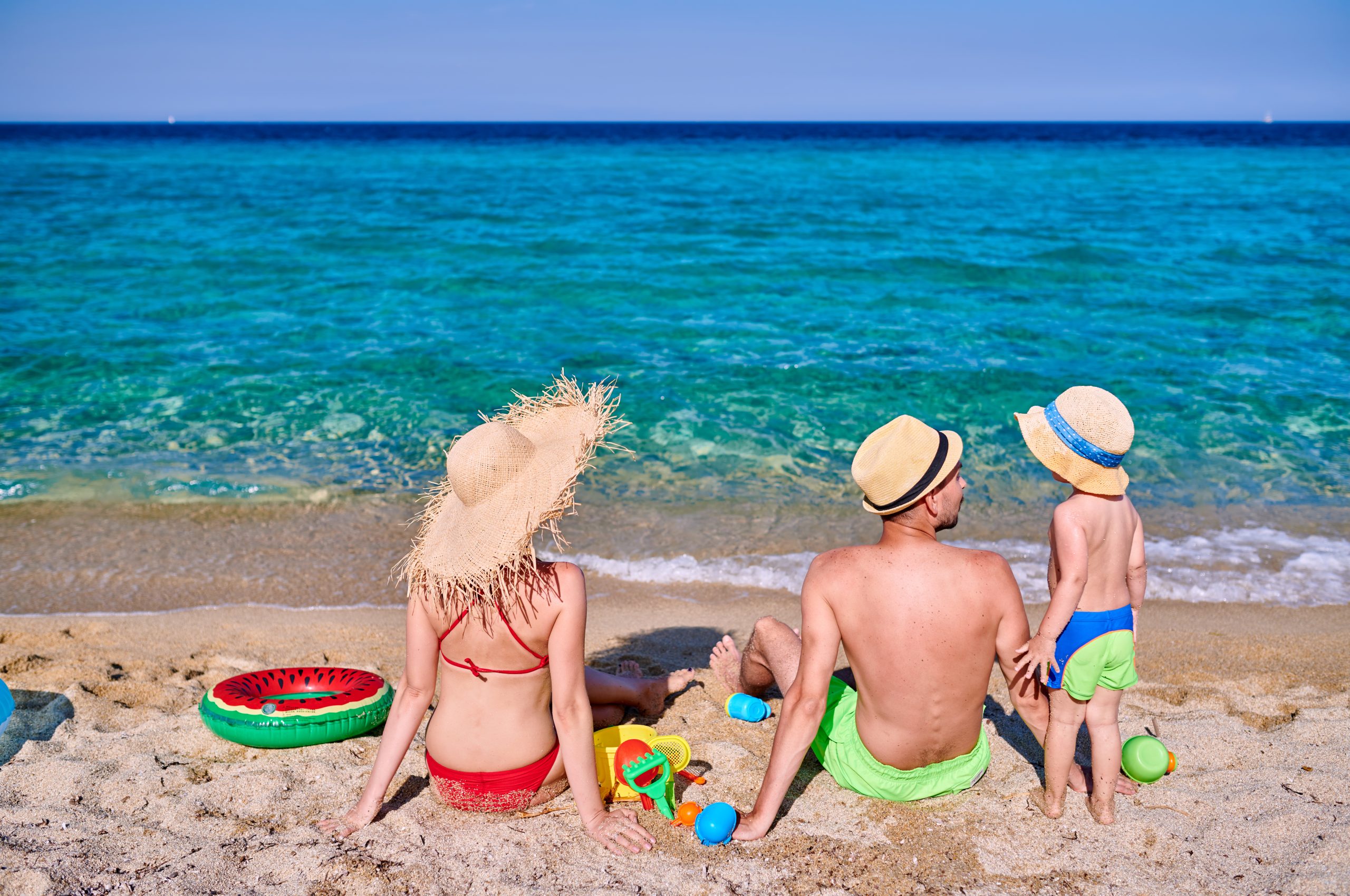 Mom, dad and toddler enjoying a family vacation on the beach in Cancun Mexico near Tim's Ocean Condos.